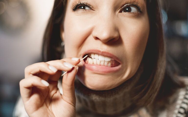 Woman picking her teeth